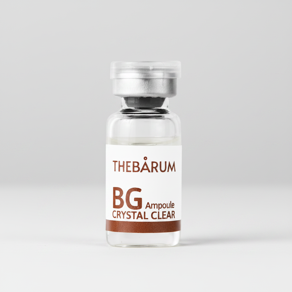 A small clear glass ampoule bottle with a silver cap and a white label reading THEBÀRUM BG Ampoule CRYSTAL CLEAR on a plain white background.