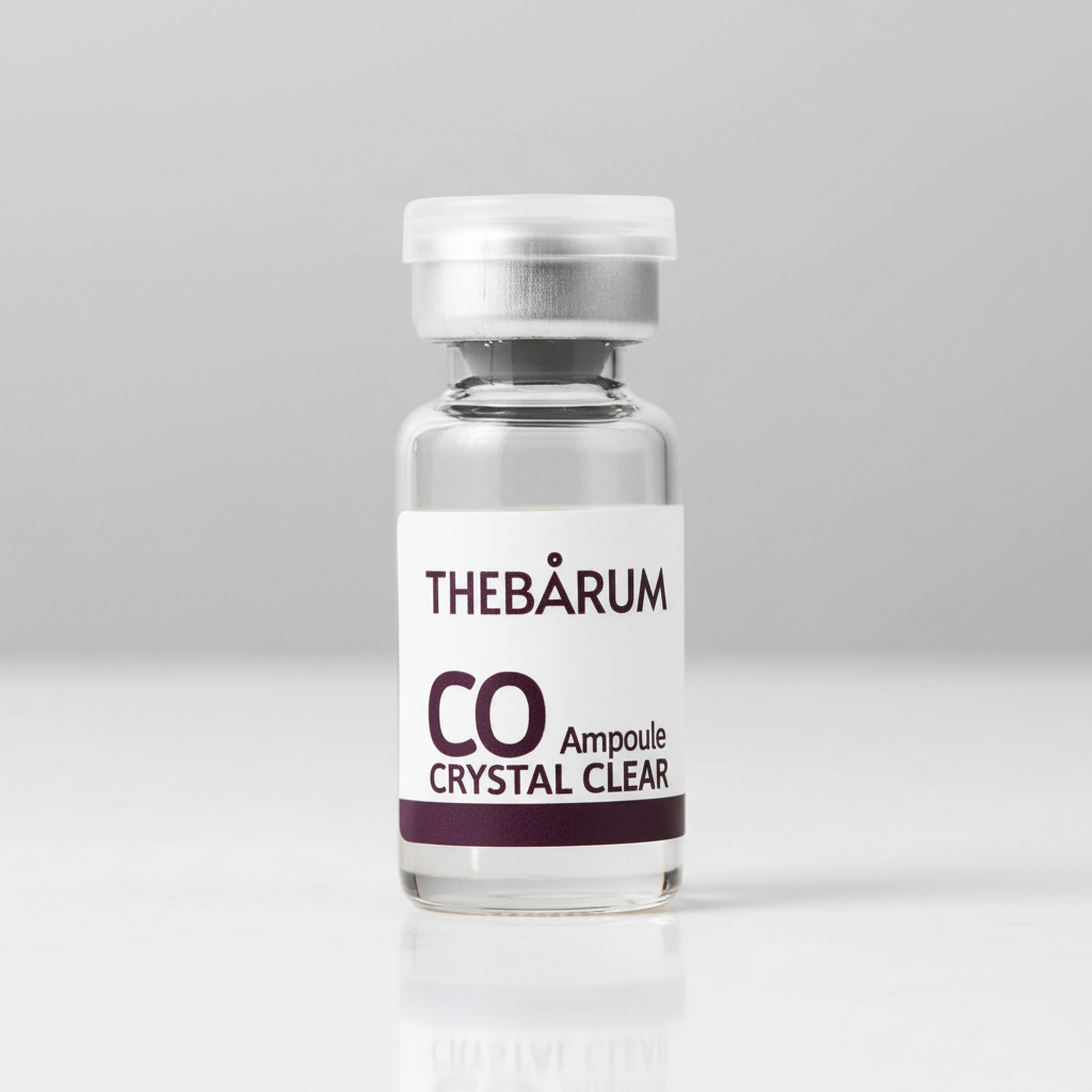 A small clear glass vial with a white label reading THEBÁRUM CO Crystal Clear, topped with a white cap, on a plain white background.