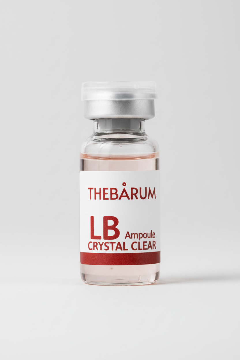 A small clear glass vial with a white label and silver cap, labeled THEBÀRUM LB Ampoule CRYSTAL CLEAR, on a plain white background.