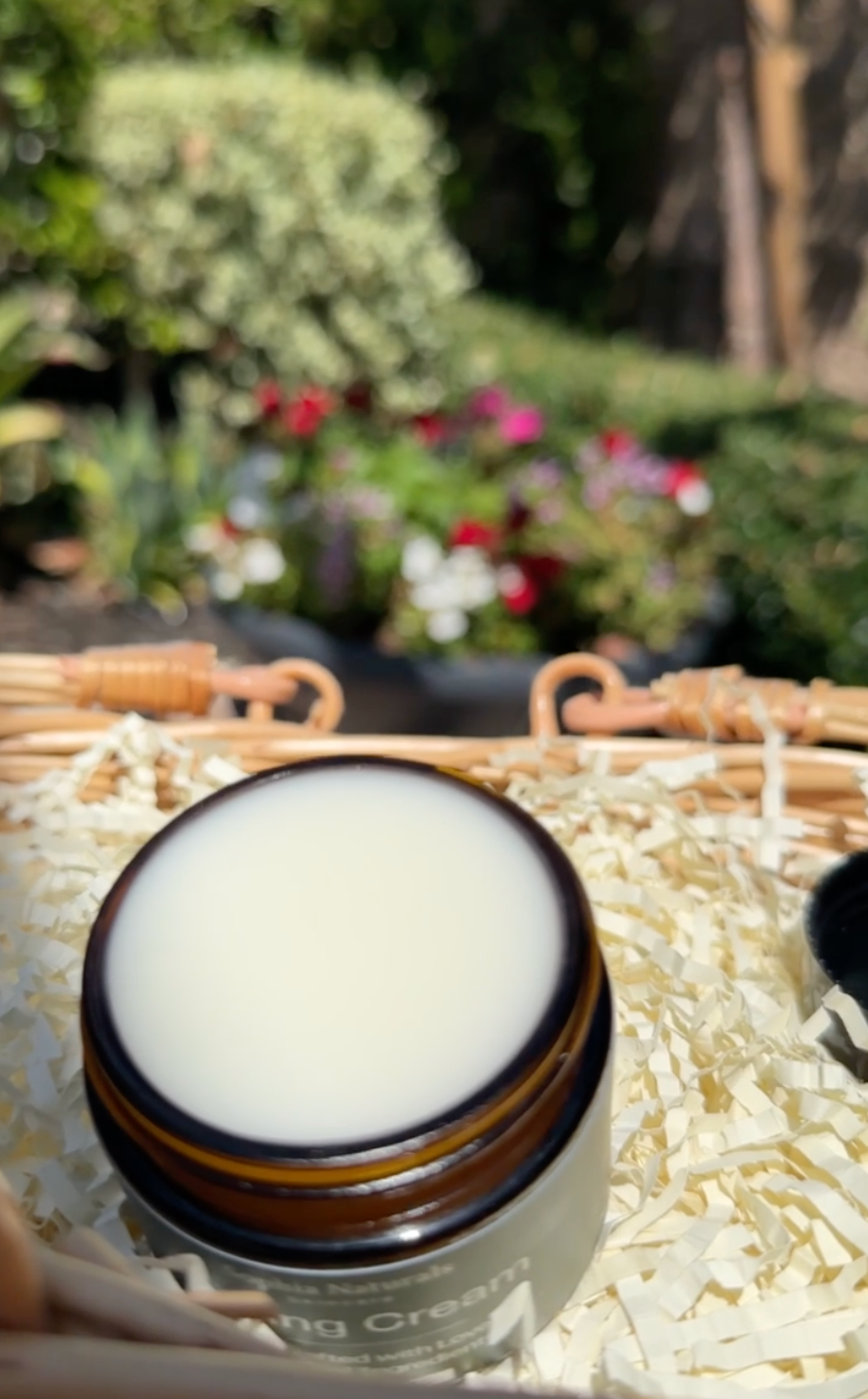 Jar of cream on a bed of rice with a blurred garden background
